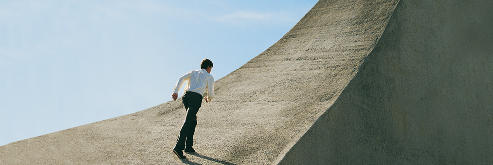 Foto: Mann erklimmt Berg aus Beton
